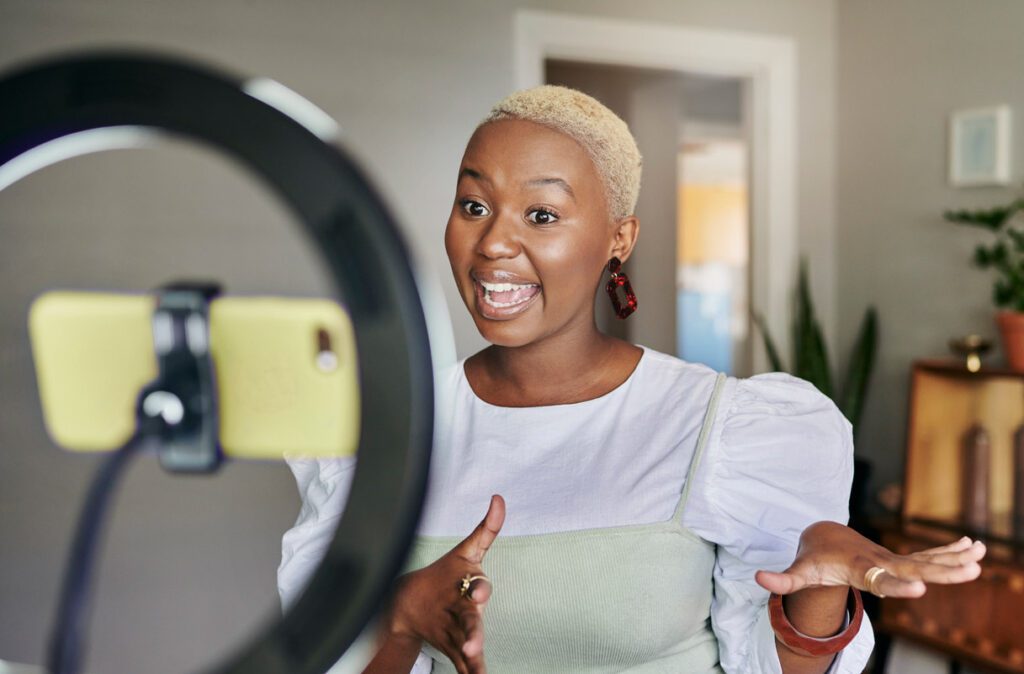female influencer with ring light and phone filming social content